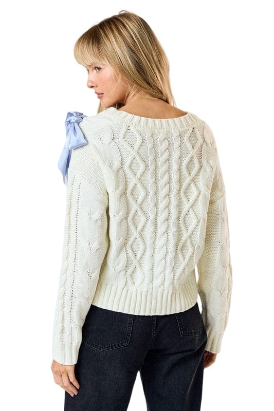 Cream knit sweater with blue ribbon